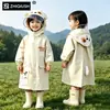 Capa de chuva infantil com compartimento para mochila, projetada para alunos do ensino fundamental usarem na escola, proporcionando proteção impermeável de corpo inteiro contra chuvas fortes, adequada para meninos e meninas.