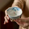 Taza de té de porcelana azul y blanca pintada a mano con esmalte debajo, featuring un pez jugando con una flor de loto, una nueva taza de té kung fu de estilo chino