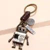 Llavero de piel de vaca con forma de robot móvil, con manos y pies tejidos retro, personalidad sencilla, colgante creativo para bolso de niña