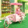Montaje de Decoración de Eventos Carrito de Flores Triciclo Móvil Montura Inversa Burro Carrito de Ventas Puesto Stand Entrada de Tienda Comercial en Centro Comercial