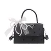 Bolsa feminina de nicho estilo coreano com laço, novo modelo 2026, bolsa de ombro única e transversal, bolsa de mão de alta qualidade com poás, bolsa quadrada pequena