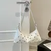 Moderna bolsa grande de design novo 2026 estilo coreano transfronteiriça com detalhes únicos de rebites, adequada para o trabalho e o trajeto diário, pode ser usada como bolsa transversal, bolsa de ombro, bolsa de mão ou bolsa de axila