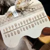 Oval Curto Estilo FrancêsUnhas postiças ovais curtas com uma borda francesa suave e elegante, doces e de fada, adequadas para looks frescos e delicados do dia a dia