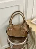 Bolso de axila versátil estilo coreano transfronterizo, moderno y de alta calidad, con un diseño texturizado tipo dumpling, acabado de gamuza y detalles de remaches, perfecto para ir al trabajo