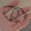 Pendientes de aro geométricos con forma de cruz estilo vintage, un toque de lujo y minimalismo, que encarnan la estética "old money", creando un look sofisticado y de alta gama.