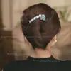 Um grampo de cabelo estiloso e versátil para mulheres, apresentando um design de bico de pato que não pressiona a parte de trás da cabeça, perfeito para criar penteados elegantes no outono e inverno.