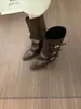 Botas femininas pretas de bico fino, salto grosso e perna larga, com um estiloso design de fivela de cinto, estilo montaria de cano alto, e comprimento que não chega ao joelho, em estilo cowboy ocidental