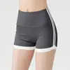 Shorts esportivos de secagem rápida com cintura alta, listras em cores contrastantes nas laterais, controle e modelagem da barriga, adequados para fitness ao ar livre e yoga.