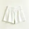 Conjunto de treino Pilates para emagrecer para mulheres, apresentando um top de regata color block e shorts atléticos de cintura alta, com pregas e anti-exposição