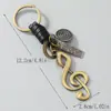 Llavero de Cuero Tejido Hecho a Mano para Coche de Hombre Estilo Retro Artístico con Accesorio de Colgante de Nota Musical de Aleación Antigua Bronce Creativo