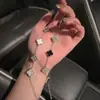 Pulseira de trevo de quatro folhas para mulheres, luxo leve, sensação de alta qualidade, design de nicho, flor de zircônia cúbica, pulseira versátil estilo panda preto e branco