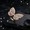Anillo de mariposa resistente, lujoso y extravagante con una zirconia cúbica escalonada y alas de mariposa caladas, un anillo transfronterizo de alta gama y moderno
