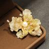 Broche tridimensional con microincrustaciones de circonitas, elegante y atmosférico, con perlas naturales de agua dulce, de cuatro colores.