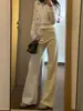 Jeans beige de mujer petite ligeramente acampanados, un estilo popular de otoño-verano, no se pegan a las piernas, estilizan, con una bonita caída, pantalones versátiles de largo hasta el suelo