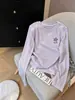 Camiseta de manga larga con cuello redondo para mujer, con un favorecedor diseño en los hombros, hecha de tela fina de color lila claro, perfecta para el otoño de 2026