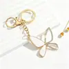 Fornecimento e Vendas do Fabricante Chaveiro Dourado Borboleta com Franja e Pom-pom Pingente para Bolsa Feminina Ornamento Pendurado com Decoração de Flores Exquisite