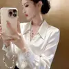 Este año, las camisas de alta gama con exquisitos diseños y adornos de encaje son tendencia. Estas camisas únicas y hermosas de satén blanco son perfectas para mujeres en las temporadas de primavera y otoño.