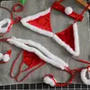 Conjunto de lencería sexy con tiras, disponible en tallas grandes para mujeres con curvas, con un sujetador y bragas con pompones, en un vibrante color rojo, perfecto para las fechas navideñas
