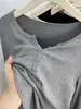 Diseño sencillo de cuello en V abotonado, hombro normal, camiseta de manga larga para mujer, estilo corto fino de principios de otoño, top acanalado irregular de algodón ajustado