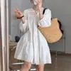 Vestido branco de renda com patchwork estilo férias e detalhes de amarração, perfeito para o verão, viagens internacionais e sessões de fotos no campo; Saia midi evasê