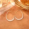 Brincos de Metal Minimalistas Europeus e Americanos em Forma de Gota com um Temperamento de Moda de Alto Padrão, Brincos Versáteis com Design de Nicho e Ganchos de Orelha Estilosos