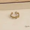 Anillo retro floral en tono café dorado, una pieza lujosa y única con un aire de alta gama, diseñado para apilar, con un borde de encaje, y perfecto para el dedo índice, ofreciendo un estilo moderno e individual