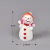 Enfeites decorativos com tema de Natal, incluindo um casal brincando na neve e uma cena de neve em miniatura, perfeitos para criar uma atmosfera aconchegante de inverno.. Estes também são acessórios DIY para decorações de plantas em vasos