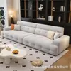Sofá italiano minimalista tipo puf en tela de terciopelo azul brumoso, con cojines cuadrados completos, asiento profundo y un diseño de líneas rectas para la sala de estar.
