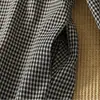Foto real de um vestido de boneca estilo japonês, apresentando um design xadrez plissado estilo Mori, um vestido de comprimento médio, artístico e vintage inspirado no estilo Mori girl com fechos de botão.