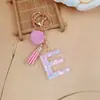 Chaveiro de letra inglesa rosa, um acessório fofo e moderno com um pompom fofo e uma franja, perfeito para projetos DIY e como pingente de bolsa para mulheres