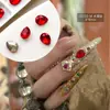 Venta al por mayor de Materiales de Uñas Trendy Estilo Chino Huanhuan, Pedrería de Punta Color Esmeralda Famosa en Internet, Pedrería Redonda de Fondo Plano y Accesorios de Uñas de Perlas