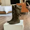 Botas altas de punta con interior elevador de altura, tacón de 4 cm, diseño de nicho y detalles fruncidos.