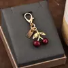 Colgante para llave de coche, bolso de gran sentido, accesorios de color dorado, oso, cereza, trébol de cuatro hojas, mariposa, bolso escolar, joyería al por mayor