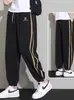 Pantalones deportivos de estilo nuevo 2026 para jóvenes, con franjas laterales para hombre, pantalones jogger versátiles, pantalones largos de retazos, pantalones casuales holgados