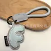 Venta al por mayor transfronteriza de llaveros japoneses y coreanos con letras en inglés, dijes para bolso de cuero dopamina, pequeños accesorios y regalos
