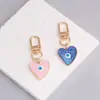 Nueva Joyería Simple Transfronteriza Creativo Colgante de Arena Movediza Ojo del Diablo Colgante de Llavero Metálico con Forma de Corazón Gota de Aceite