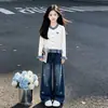 Traje energético da moda para menina: um cardigã longo de mangas compridas, doce e adornado com um laço, combinado com calças jeans de corte folgado, perfeito para a primavera e o outono
