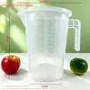 Taza medidora de plástico con tapa y escala en stock, especializada para tiendas de té de burbujas, jarra medidora doméstica de grado alimenticio, resistente a altas temperaturas