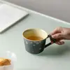 Copo de cerâmica pintado à mão para água com padrões florais brancos, apresentando uma estética Zen japonesa, adequado para uso doméstico ou de escritório, e projetado para infusão lenta