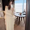 Nuevo conjunto de tres piezas de punto para mujer en color albaricoque, color hora del té, que incluye cárdigan, top tipo camisola y falda.