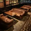 Cadeira de chefe europeia e americana neoclássica estilo hotel, sofá de lazer de encosto alto com design de puxador e conjunto de pufe, adequado para vilas, apresentando couro genuíno e um sofá estilo americano