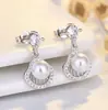 Novos brincos de tarraxa em prata de lei S925, um item muito vendido no Japão e na Coreia do Sul, apresentando um design moderno, minimalista e luxuoso com detalhes em diamante, e um design em formato de leque com concha e pérola para mulheres
