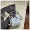 Bolso de mano pequeño exquisito transfronterizo para mujer 2026 nuevo bolso de hombro con patrón tejido para el trabajo y los desplazamientos bolso cruzado tipo cubo