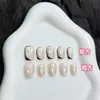 ¡Guau! Uñas postizas estilo francés en blanco y negro con un degradado morado, detalles dorados y un aspecto sofisticado y elegante que realza el cutis, con un diseño de ojo de gato