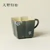 Pintada a mano con tinta y musgo, con un diseño de pequeñas flores blancas, esta taza de té cuadrada encarna la estética Zen japonesa y está diseñada para uso personal.