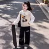 Roupa da moda e casual para crianças mais velhas: um colete fofo com tema de urso, uma camisa com gola de boneca e calças largas versáteis de retalhos xadrez