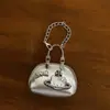 Bolsa de cuero remachada a mano con colgante de cuero plateado 2025 nuevo bolso de saturno plateado de alta gama colgante de polvo para bolso llavero