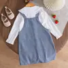 Conjunto de dos piezas fresco y lindo para niña: camisa blanca de manga larga con cuello de muñeca combinado con una falda de mezclilla con tirantes bordada de fresas.
