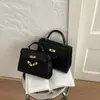 Bolso de mano de nicho retro europeo y americano 2026 nuevo, bolso tipo Kelly para mujer, bolso versátil de color liso simple para hombro y cruzado