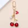 Llavero de corazón de cereza dulce más vendido transfronterizo con colgante de perla, accesorio de resina con colgante de corazón para bolso, estilo femenino, venta al por mayor